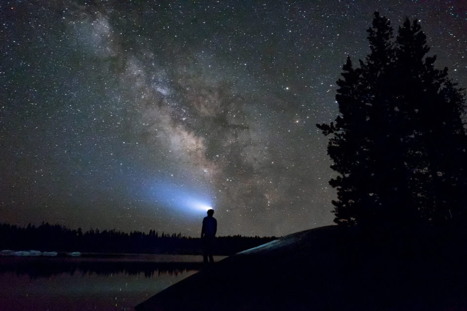 man with headlamp looking at night sky