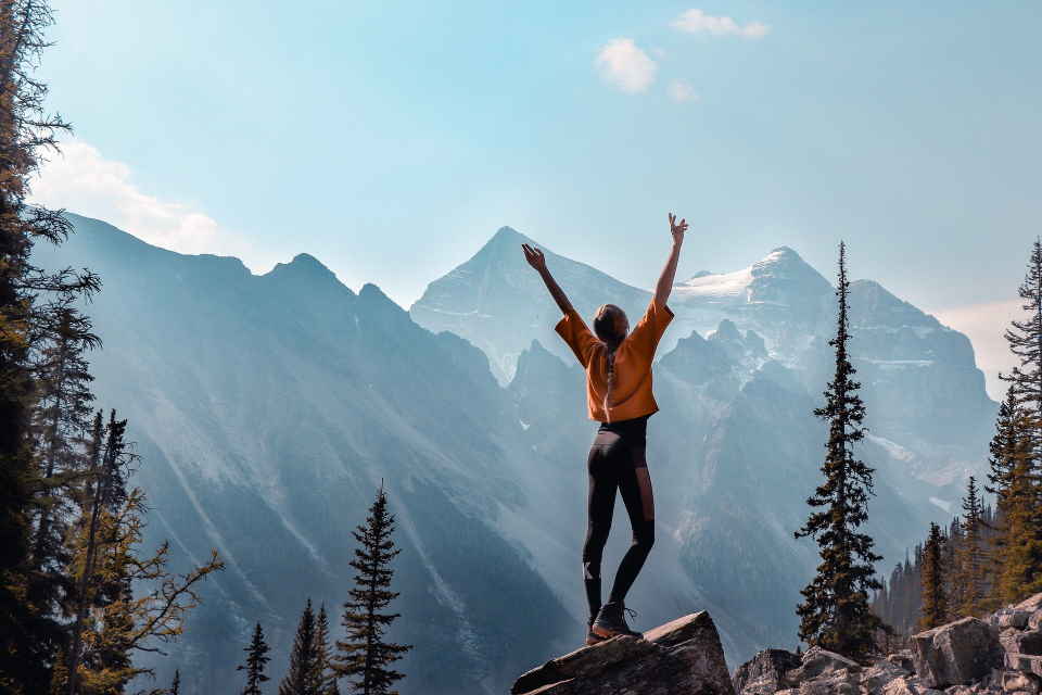 girl raising hands on a hike