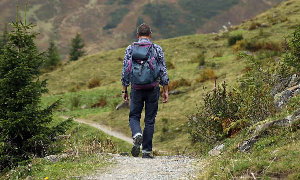 man hikes down a path