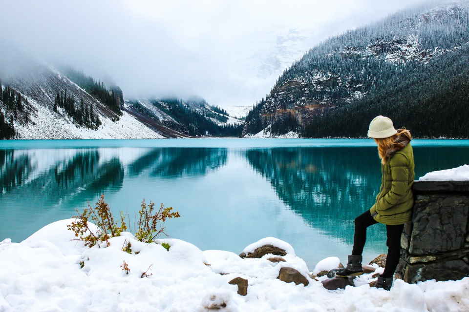 Woman hiking in front of ice lake